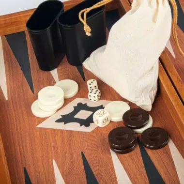 Detalje af de sorte terningebægre og stofposen i sættet